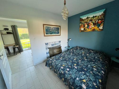 1 dormitorio con 1 cama y una pintura en la pared en Ecrin de verdure Entre forêt et océan en Saint-Martin-de-Seignanx
