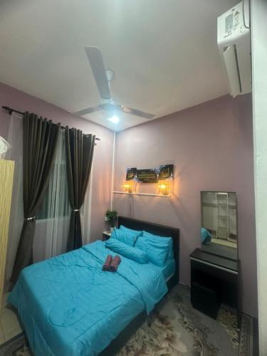 a bedroom with a blue bed and a mirror at Homestay Afeef Jerantut in Jerantut