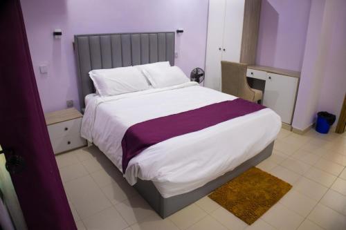 a bedroom with a large bed in a purple room at Klulead Garden and Suites in Ijebu Ode