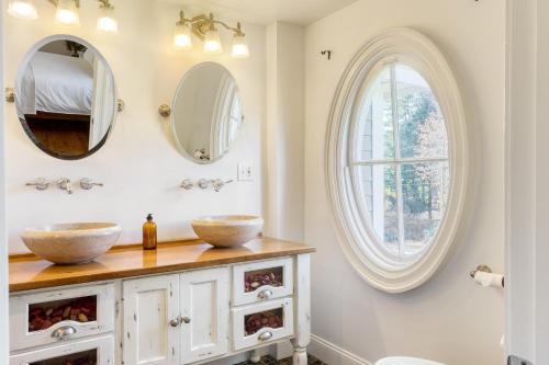La salle de bains est pourvue de 2 lavabos et d'une fenêtre. dans l'établissement Rockspring by AvantStay Huge Berkshires Estate, à Stockbridge