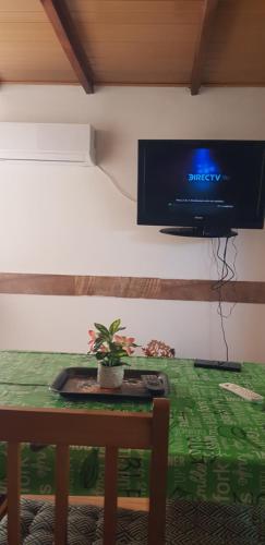 a room with a table with a tv on the wall at La Quimera del Águila in Atlántida