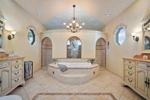 a large bathroom with a tub and a chandelier at Tropical Pool Paradise - Minutes from the Beach Venice in Nokomis