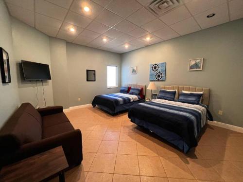 a living room with two beds and a couch at Tropical Pool Paradise - Minutes from the Beach Venice in Nokomis