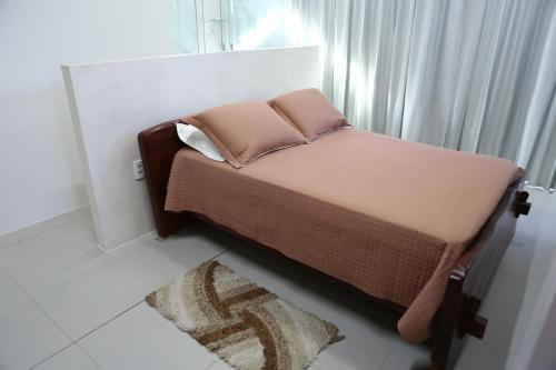 ein kleines Bett in einem Zimmer mit Fenster in der Unterkunft Excelente chale com Wi-Fi em Itabaiana Sergipe in Itabaiana