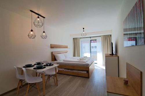Schlafzimmer mit einem Bett, einem Tisch und Stühlen in der Unterkunft Apartment KORZO 318/3 in Lipno nad Vltavou
