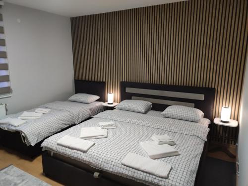 Dos camas en un dormitorio con toallas blancas. en Guesthouse Kruna Višegrad, en Višegrad