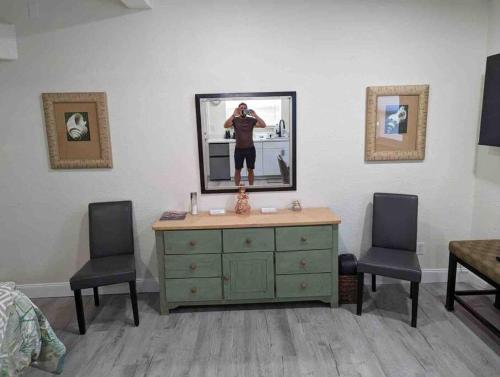 une chambre avec une commode avec un homme dans le miroir dans l'établissement Renovate Large Studio 21-Directly Across Beach, à St. Pete Beach