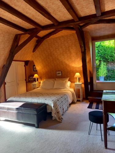 1 dormitorio con cama grande y ventana grande en LES TALOCHES, en Tourtoirac