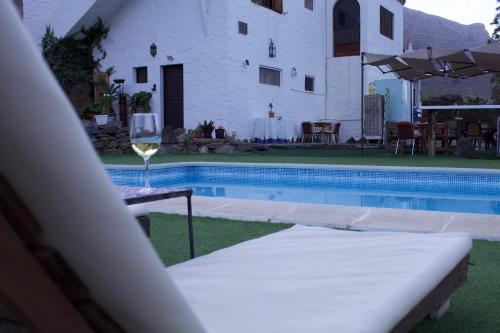 - un verre de vin assis sur une table près de la piscine dans l'établissement Mogán Natural, à Mogán