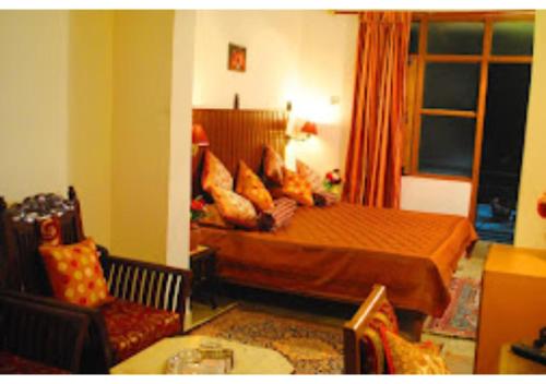 - une chambre avec un lit et des oreillers dans l'établissement HOTEL HARMONY, KHAJURAHO MADHYA PRADESH, à Khajurâho