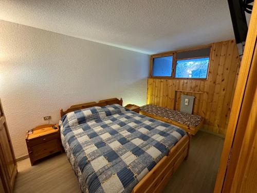 ein kleines Schlafzimmer mit einem Bett und einem Fenster in der Unterkunft Sasso Rosso Apartment in Folgarida