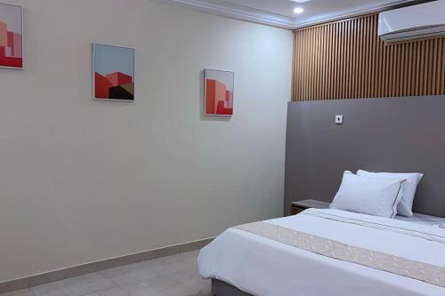 a bedroom with a bed and paintings on the wall at Luxury 3-bedroom apartment in Accra
