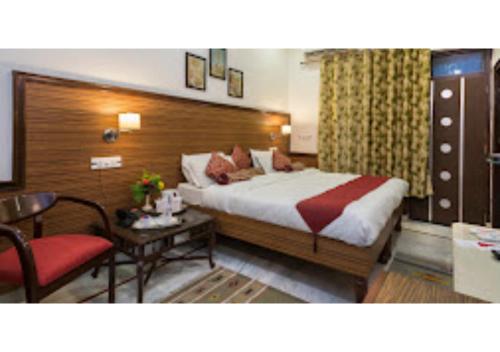 - une chambre avec un lit, une table et une chaise dans l'établissement HOTEL HARMONY, KHAJURAHO MADHYA PRADESH, à Khajurâho