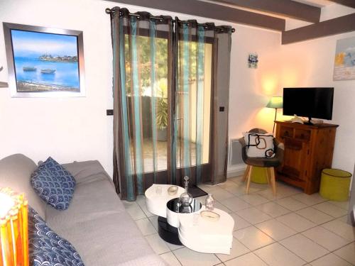 un salon avec un canapé et une télévision dans l'établissement Saint Georges de Didonne - MAGNIFIQUE VILLA en RESIDENCE avec terrasse, à Saint-Georges-de-Didonne
