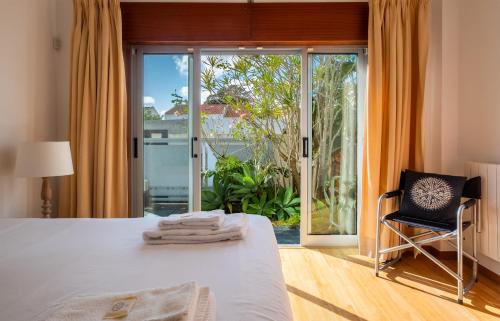 ポンタ・デルガダにあるCasa Do Limoeiroのベッドルーム1室(ベッド1台付)、スライド式ガラスドアが備わります。