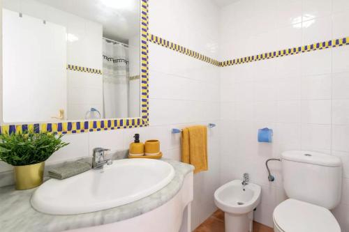 une salle de bains blanche avec toilettes et lavabo dans l'établissement "Servall Host" Alicante 2 Piscines et Parking privé, à Mutxamel