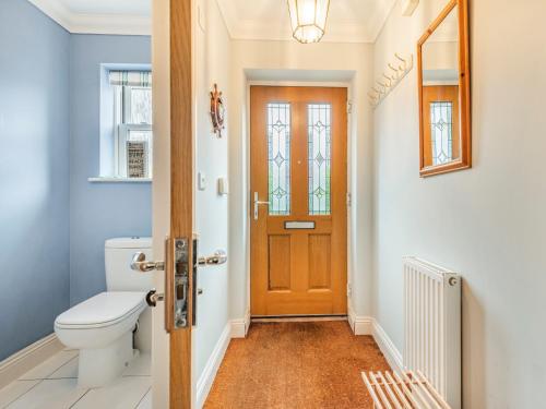 a bathroom with a toilet and a wooden door at 3 Bed in Christchurch 73946 in Christchurch