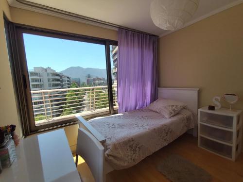 a bedroom with a bed and a large window at Habitación Acogedora en Vitacura in Santiago