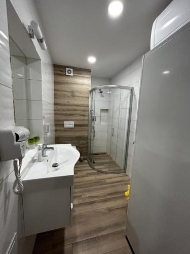 La salle de bains est pourvue d'une douche et d'un lavabo blanc. dans l'établissement SIEDEM WYDM, à Rowy
