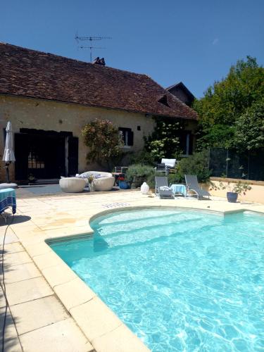a swimming pool in front of a house at LES TALOCHES in Tourtoirac