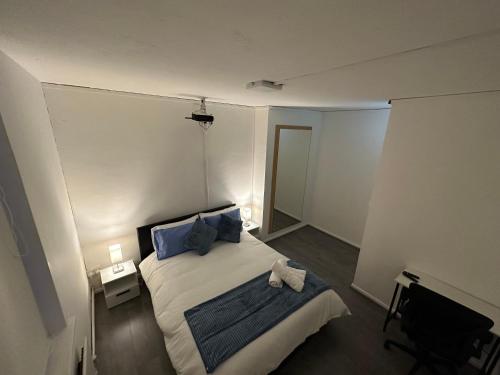 a bedroom with a bed with blue pillows and a mirror at Unique Double Bedroom in London