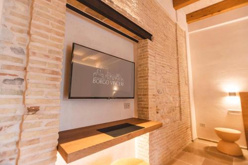 einen TV an einer Wand mit Ziegelwand in der Unterkunft Borgo Vinceri in Lucera