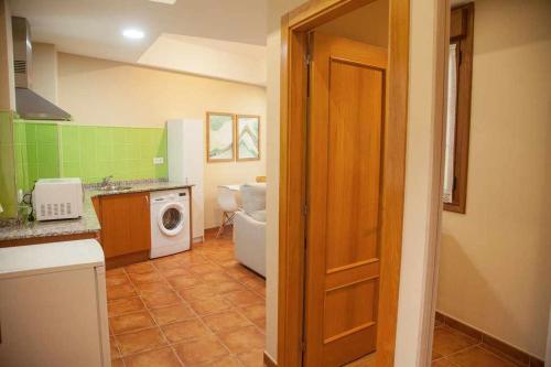eine Küche mit einem WC, einer Waschmaschine und einem Trockner in der Unterkunft Cumbres de los Picos Apartamento La Yedra in Poo de Cabrales