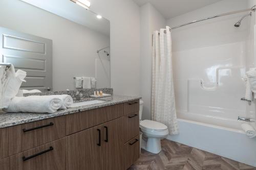 a bathroom with a tub and a toilet and a sink at Yugo Guest Suites in Urbana