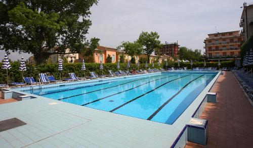 uma grande piscina com espreguiçadeiras e sidx sidx em Hotel Galles em Lido di Jesolo