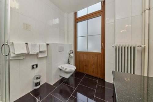 a bathroom with a toilet and a window at Moselhotel Römischer Kaiser in Bernkastel-Kues