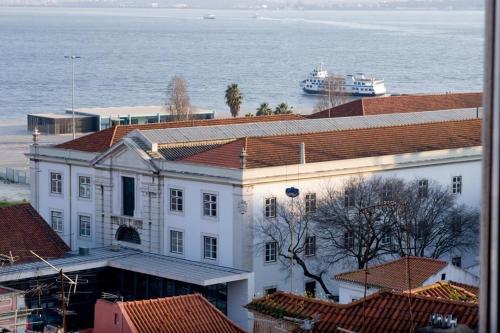 a large white building with a cruise ship in the water at Pequeno Hostel in Lisbon