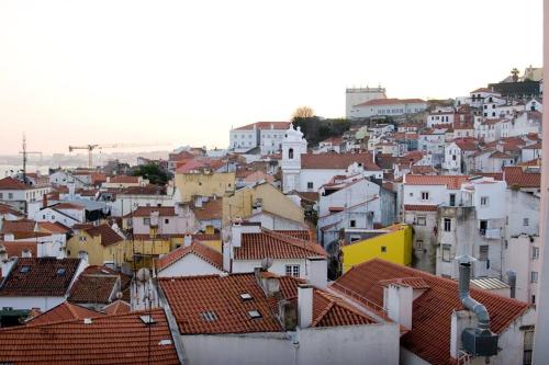 a view of a city with roofs and buildings at Pequeno Hostel in Lisbon
