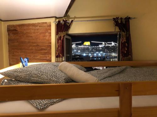 a bed with a window with a view of a city at Pequeno Hostel in Lisbon