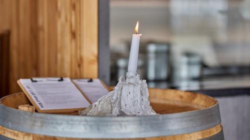 a candle in a wooden bowl with a book at Moselhotel Römischer Kaiser in Bernkastel-Kues
