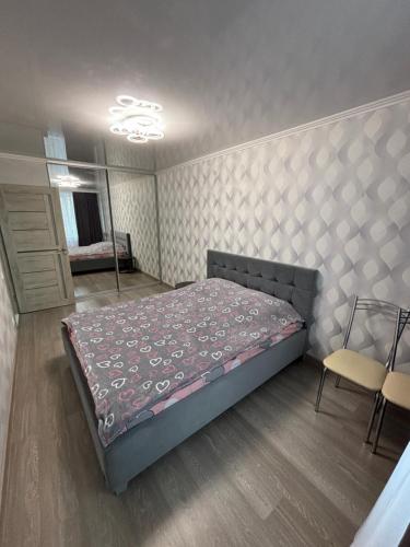 a bedroom with a bed and a mirror and a chair at Квартира для приятного отдыха! Удобства и комфорт! in Tiraspol