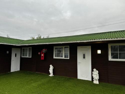 two white statues standing outside of a house at 10B sunset park homes in Brackley