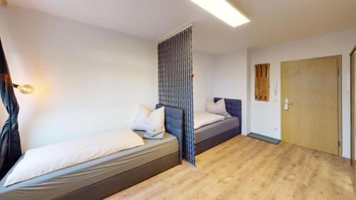 Habitación con 2 camas y pasillo con puerta en CozyWork Studio Apartment 7, en Hohenmölsen