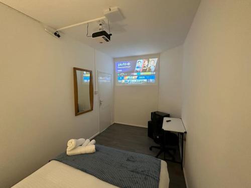 a small room with a bed and a television at Small cozy private bedroom zone1 in London