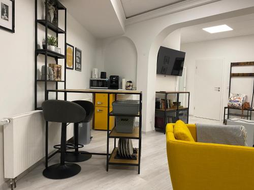 a living room with a yellow couch and a yellow chair at Chice, urbane Oase mit Arbeitsplatz in Troisdorf