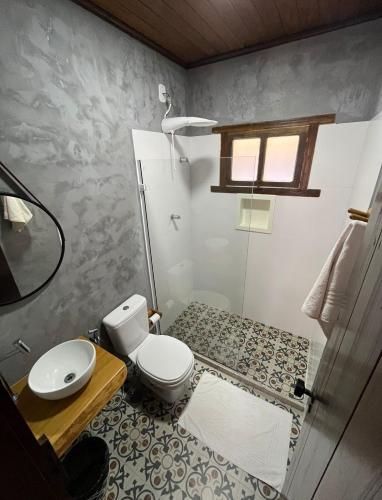 a small bathroom with a toilet and a sink at Pousada Veleiro Itaúnas in Itaúnas