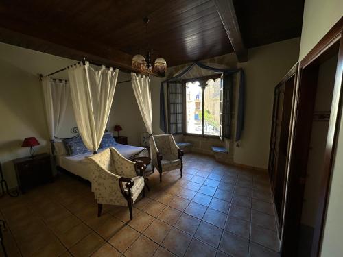 - une chambre avec un lit, deux chaises et une fenêtre dans l'établissement Hotel De La Villa, à Rubielos de Mora