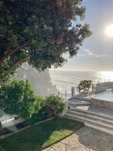 a view of the ocean with a tree and stairs at Casa Condessa - Create memories in Azenhas do Mar