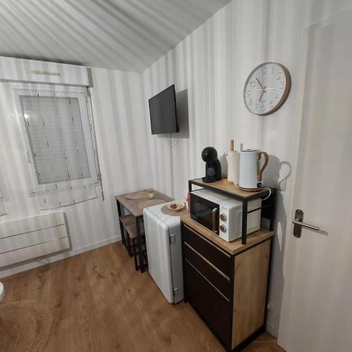 Cette chambre dispose d'un four micro-ondes et d'une table avec une horloge. dans l'établissement Le Studio Zen 