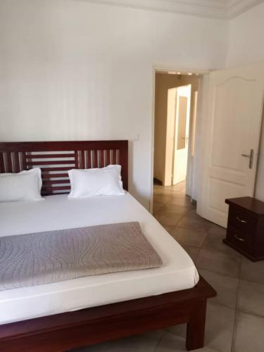 a bedroom with a large bed with a wooden headboard at Biagui in Dakar