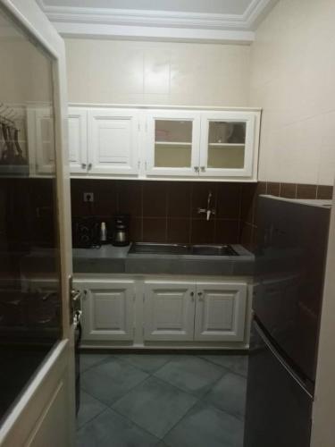 a kitchen with white cabinets and a black sink at Biagui in Dakar
