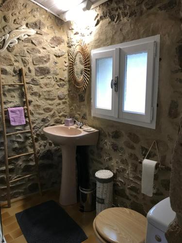 ein Bad mit einem Waschbecken und einem Fenster in der Unterkunft Chambre d'hôte Lavande - Le soleil des Cévennes in Saint-Jean-du-Gard