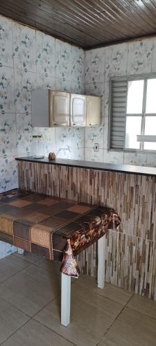 una cocina con un banco en el medio de una habitación en Kitnet mobiliada, quarto, banheiro, cozinha americana, en Luziânia