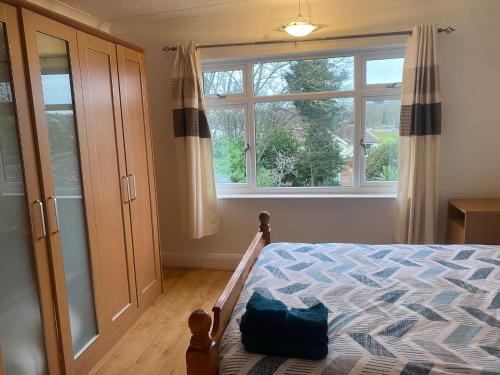 ein Schlafzimmer mit einem Bett und einem großen Fenster in der Unterkunft Spacious home near city hospital in Nottingham