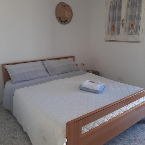 een groot bed in een slaapkamer met een klok aan de muur bij Camera Brupier in Ruvo di Puglia