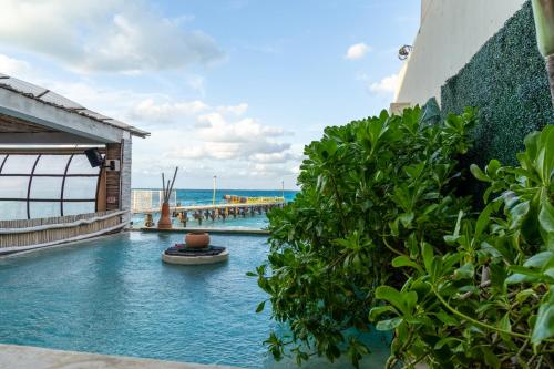 a pool at a resort with the ocean in the background at La Palma Beachfront Hotel Boutique - Self Check In in Cancún
